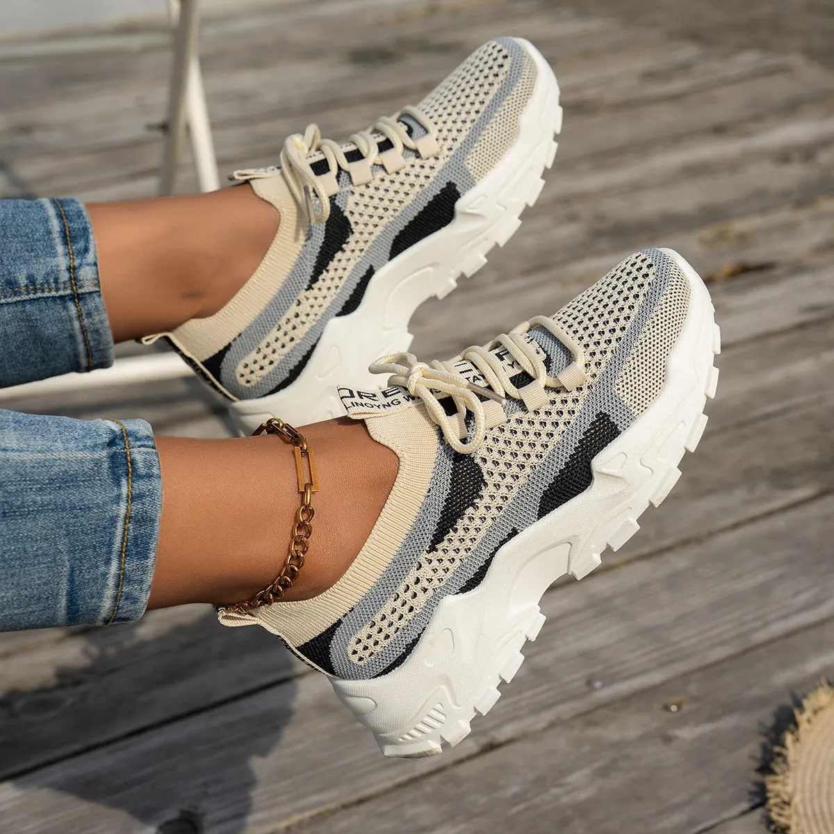 Women's Flyknit mesh lace-up sneakers in a grey colourway with a round toe and flat rubber sole.