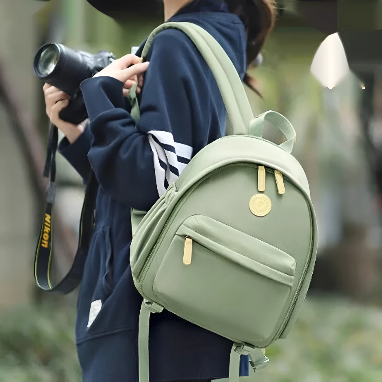 Green polyester shoulder camera bag for women with a curved strap and front patchwork panel.