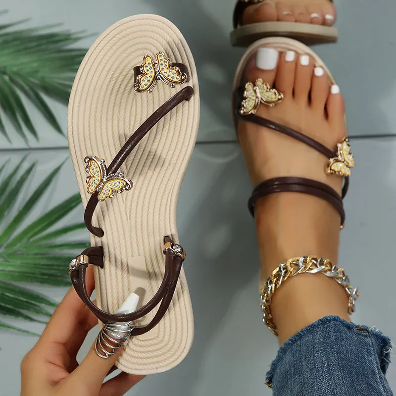 Women's butterfly flat sandal with gold sequins and bow detail, synthetic leather upper, rubber sole, on light background