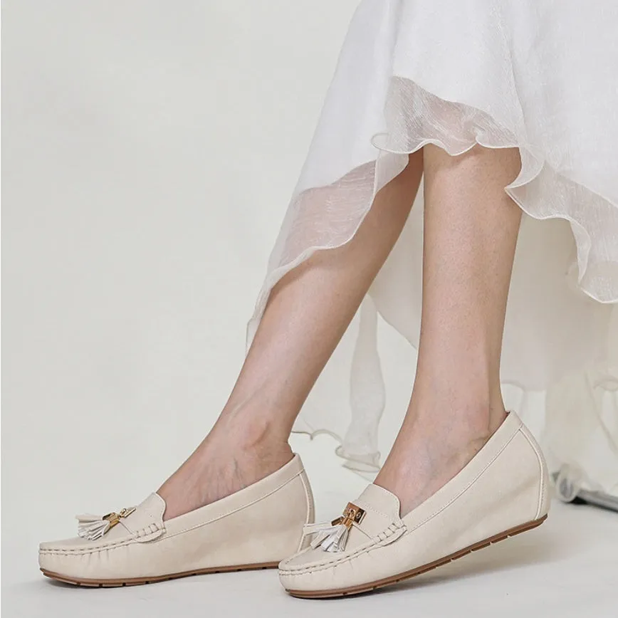 A pair of nude-coloured height-increasing shoe insoles with a round toe and a raised heel section.