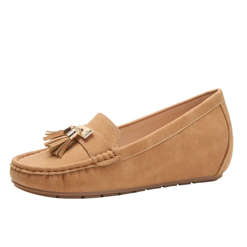 A pair of nude-coloured height-increasing shoe insoles with a round toe and a raised heel section.