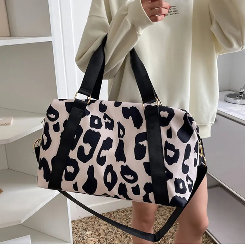 Women's large travel duffel bag with cow pattern, black, showing zippered main compartment and soft handle