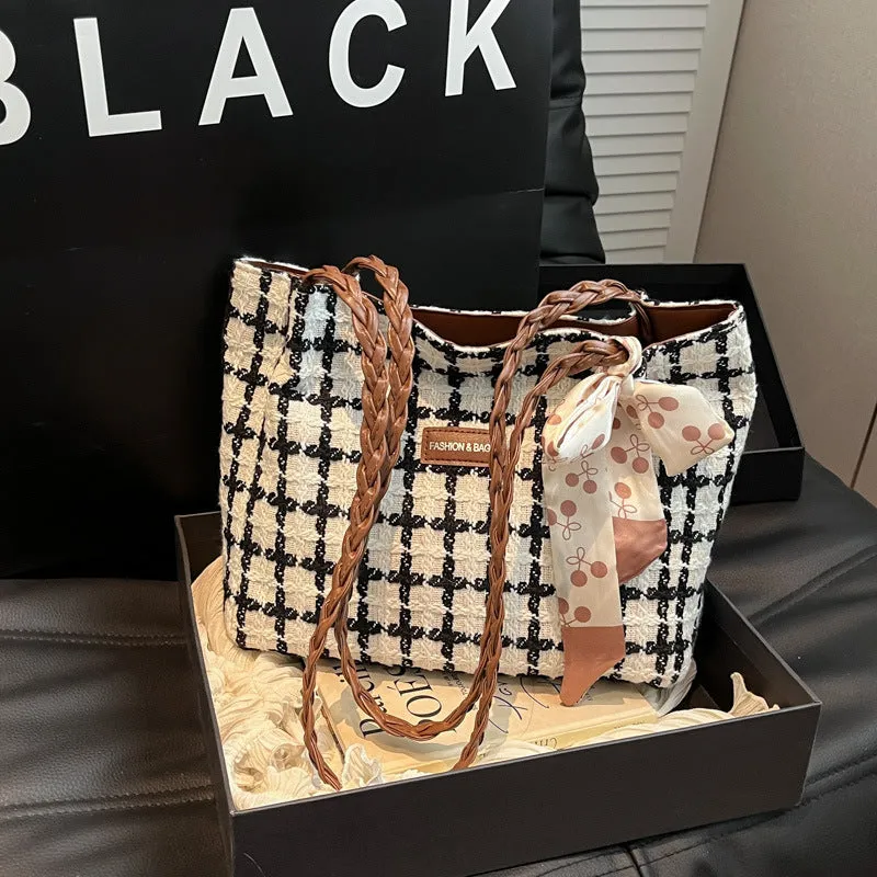 Black woven wool shoulder bag with horizontal square shape showing internal organiser compartments