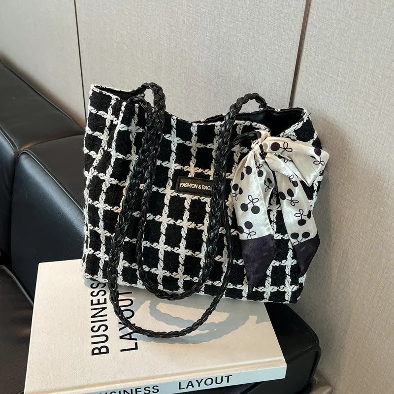 Black woven wool shoulder bag with horizontal square shape showing internal organiser compartments