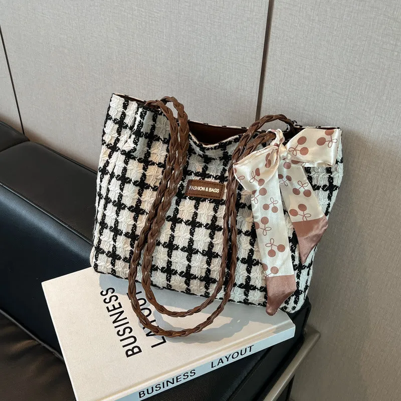 Black woven wool shoulder bag with horizontal square shape showing internal organiser compartments