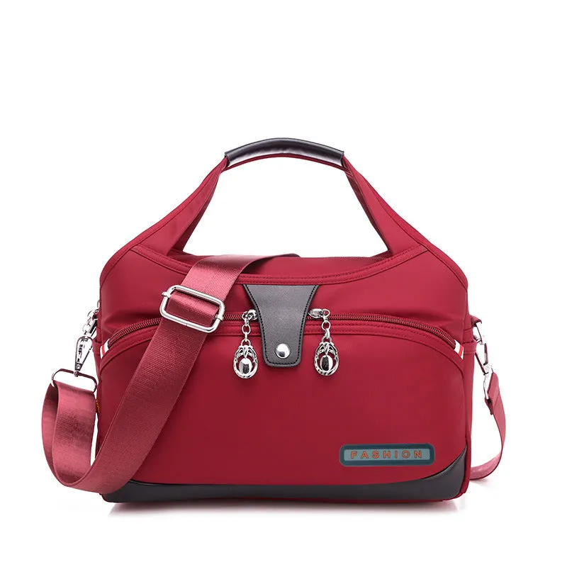 Women's crossbody bag in Oxford cloth with zippered closure and adjustable shoulder strap, 29cm long, available in multiple colours