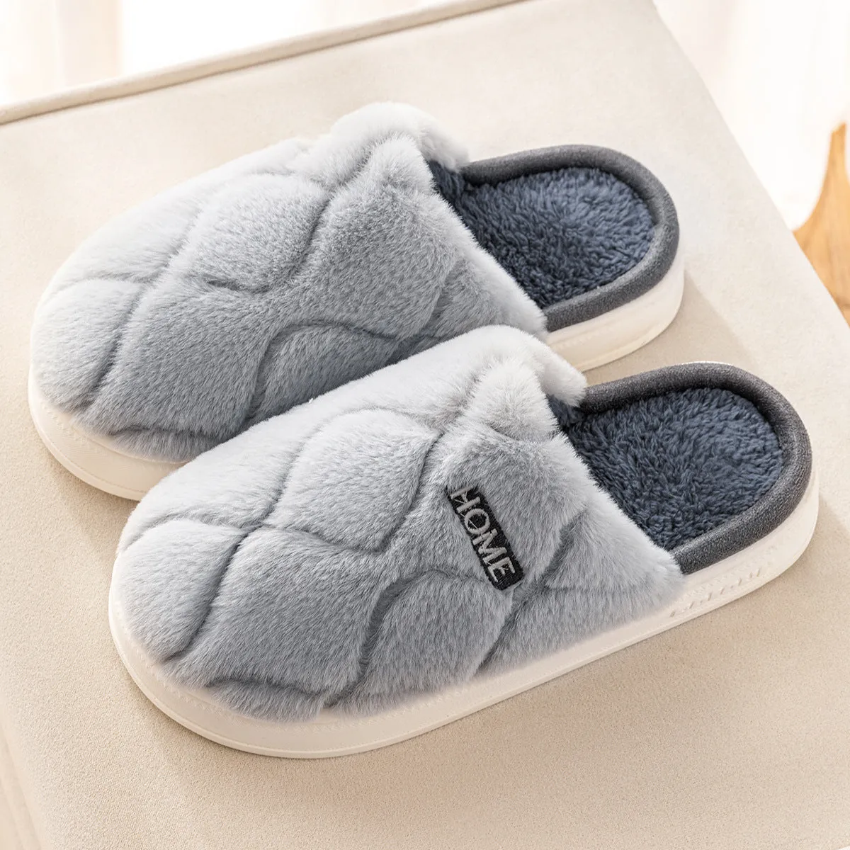 Plush indoor slippers in light gray with car stitching detail on the upper and PVC sole
