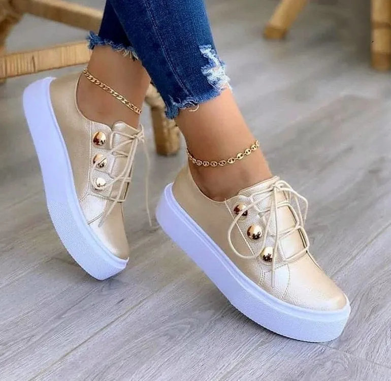Women's lace-up rivet flats sneakers in white with round toe and front tie closure on polyurethane sole