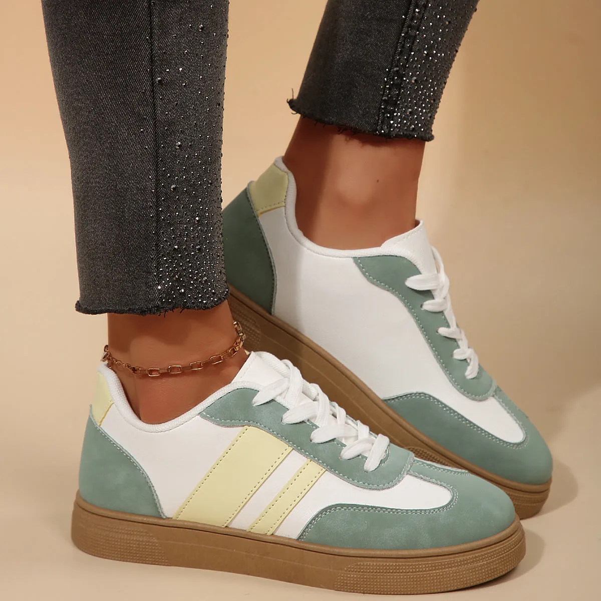 Green women's low-top retro sports shoes with cross straps and a flat rubber sole.