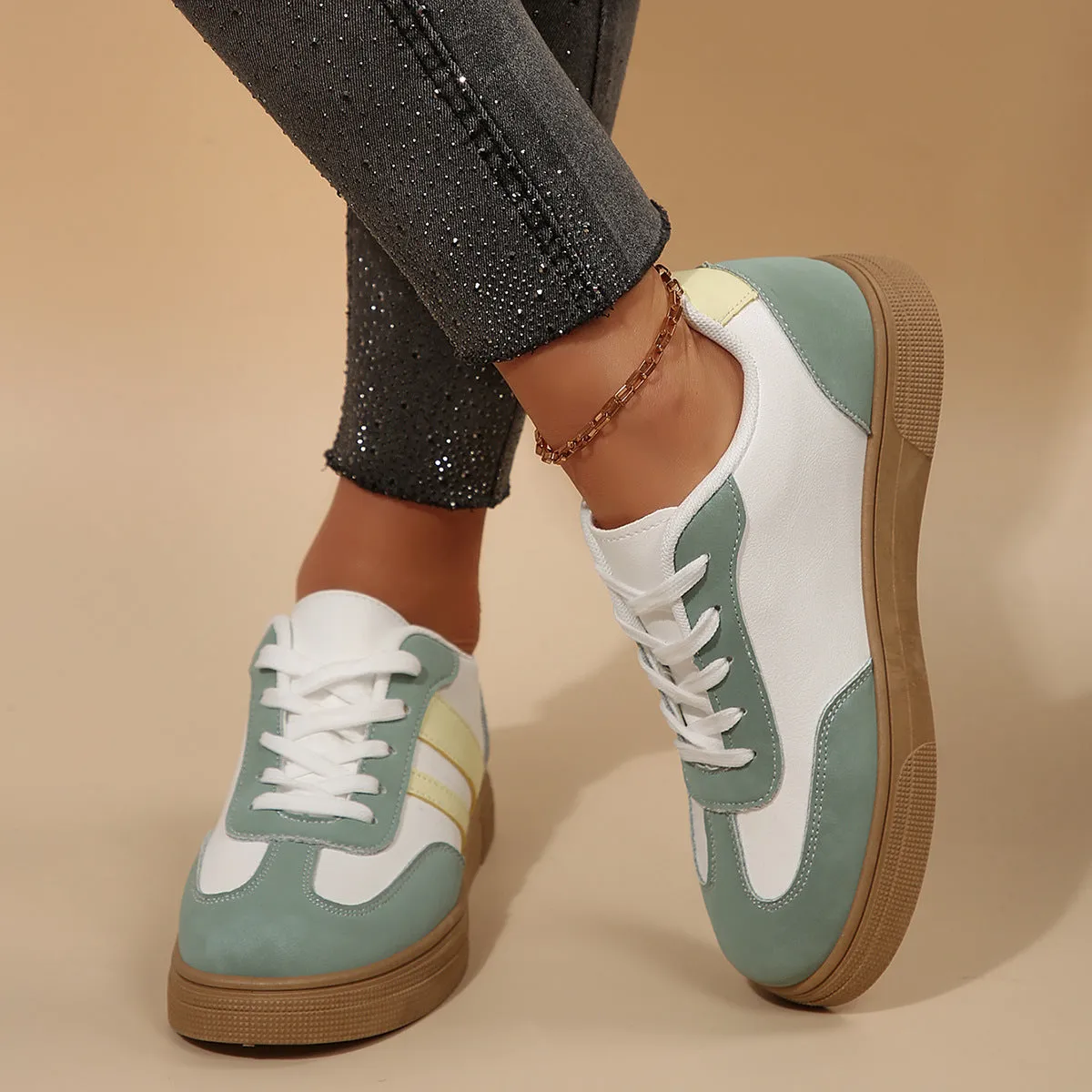 Green women's low-top retro sports shoes with cross straps and a flat rubber sole.