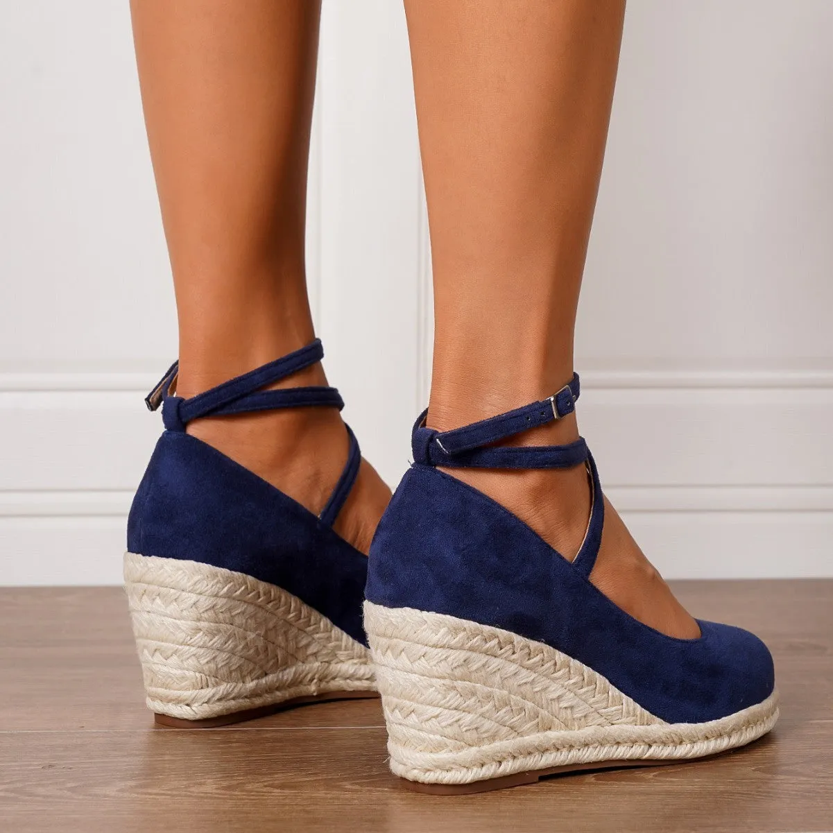 Dark blue suede straw woven wedge closed toe high heels with buckle fastening on a white background