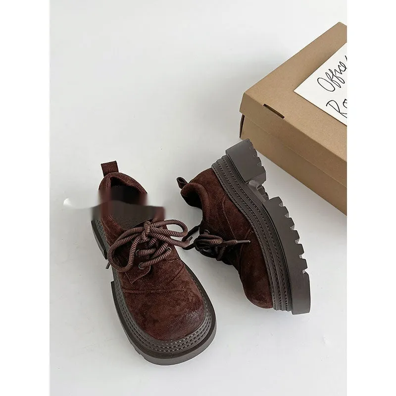 Retro British style loafers in solid colour with round toe and low muffin heel on a plain background