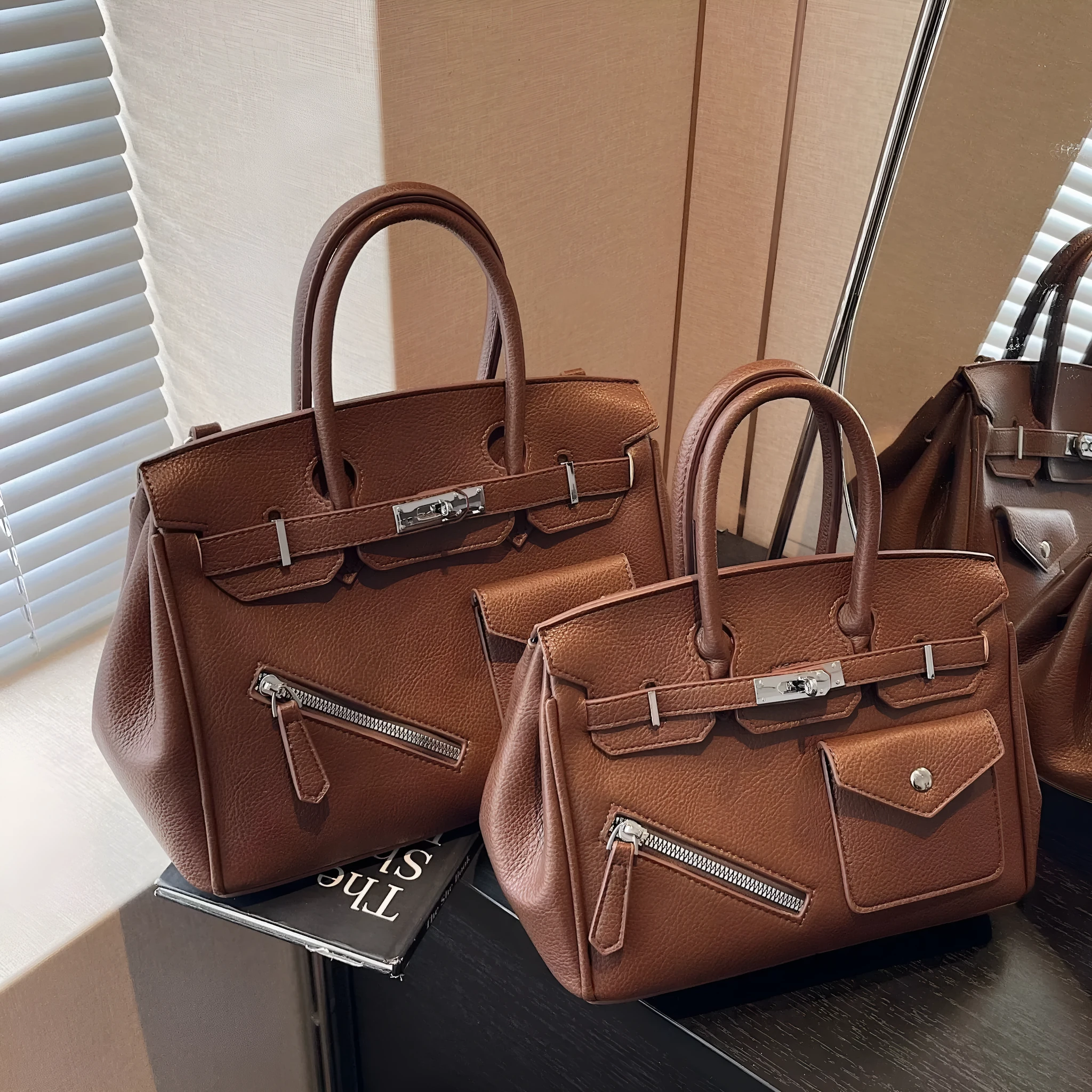 PU leather retro cross-body bag in solid colour with stitching, lock detail, and horizontal square shape