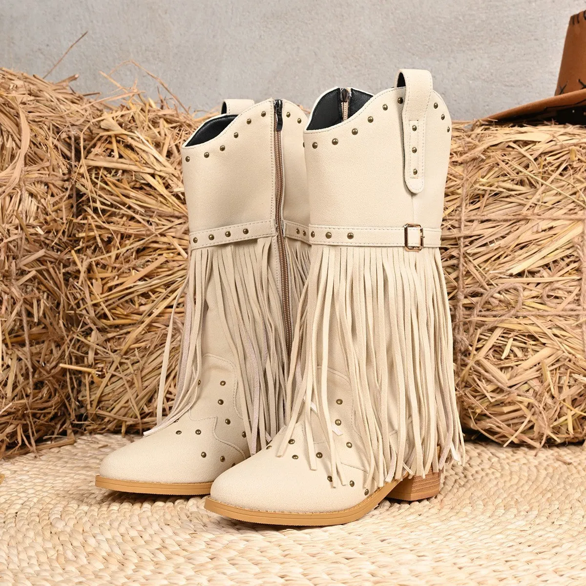 Beige women's western cowboy boots with mid heel, side zipper, and tassel details on a white background