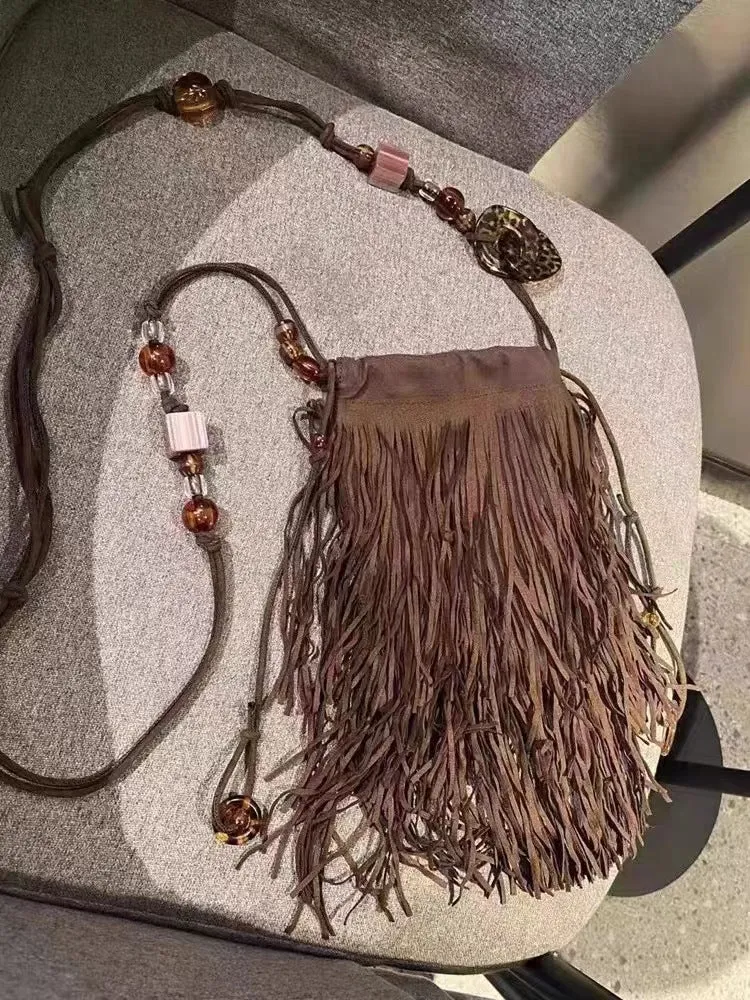 Maroon drawstring beaded tassel crossbody bag with soft plush exterior and single shoulder strap