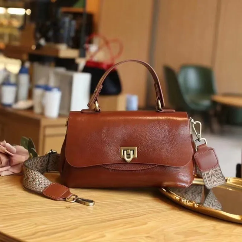 Dark brown women's saddleback leather handbag with double straps and an open front pocket.