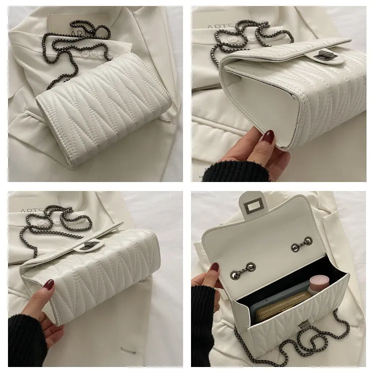 Small beige textured diamond pattern PU women's handbag with a soft handle on a table.