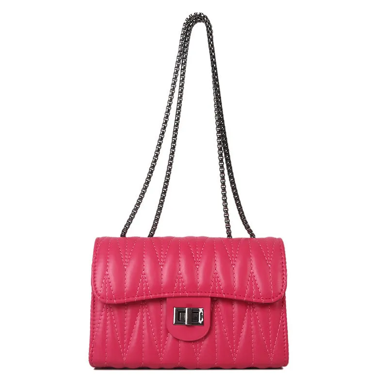 Small beige textured diamond pattern PU women's handbag with a soft handle on a table.