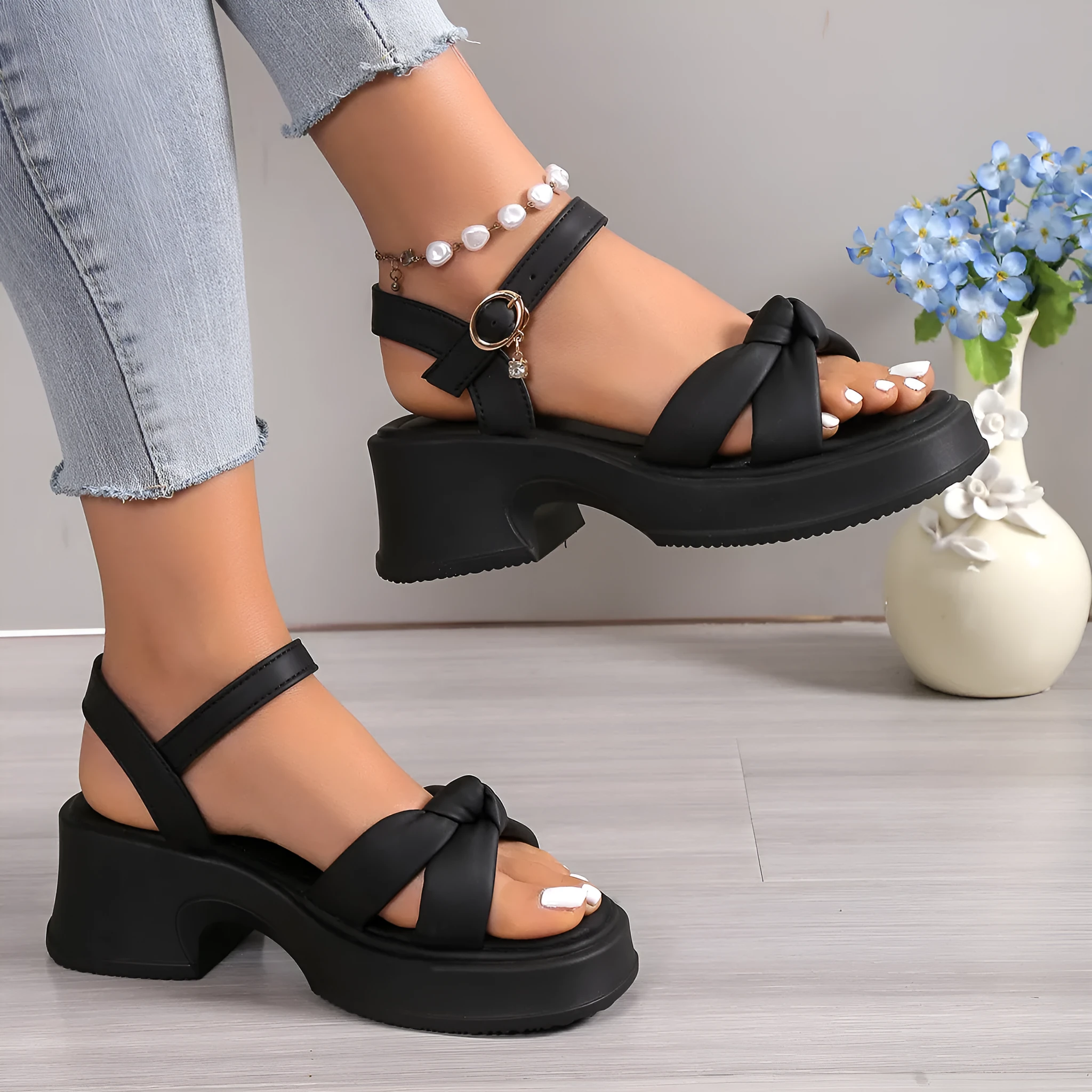 Black high-heel slippers with a thick rubber sole and a button fastening over the instep.