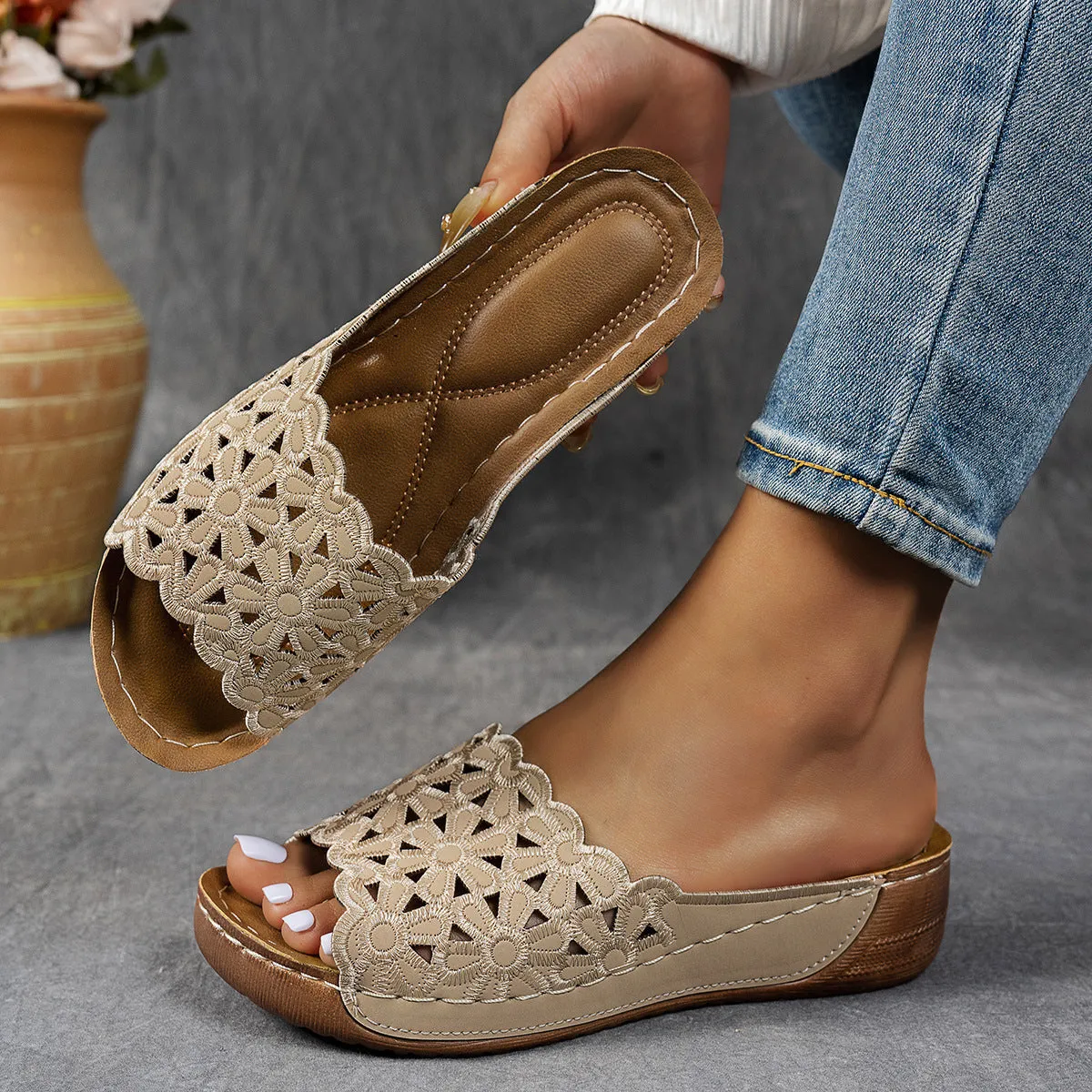 Women's black wedge beach slippers with flower cutout design and open fish mouth toe.