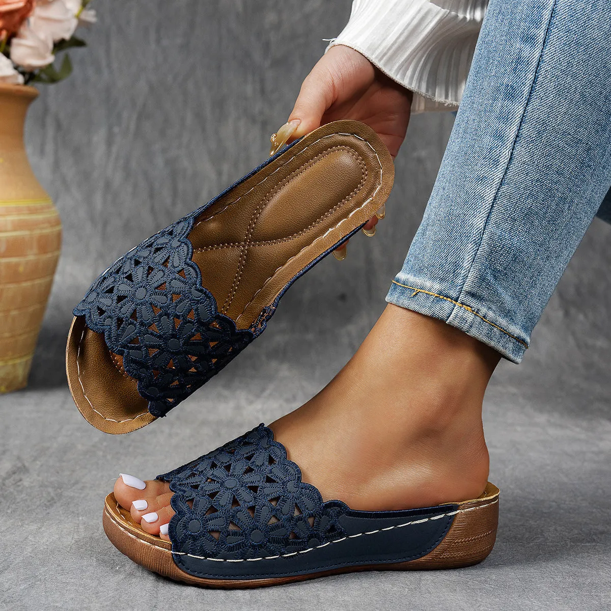 Women's black wedge beach slippers with flower cutout design and open fish mouth toe.