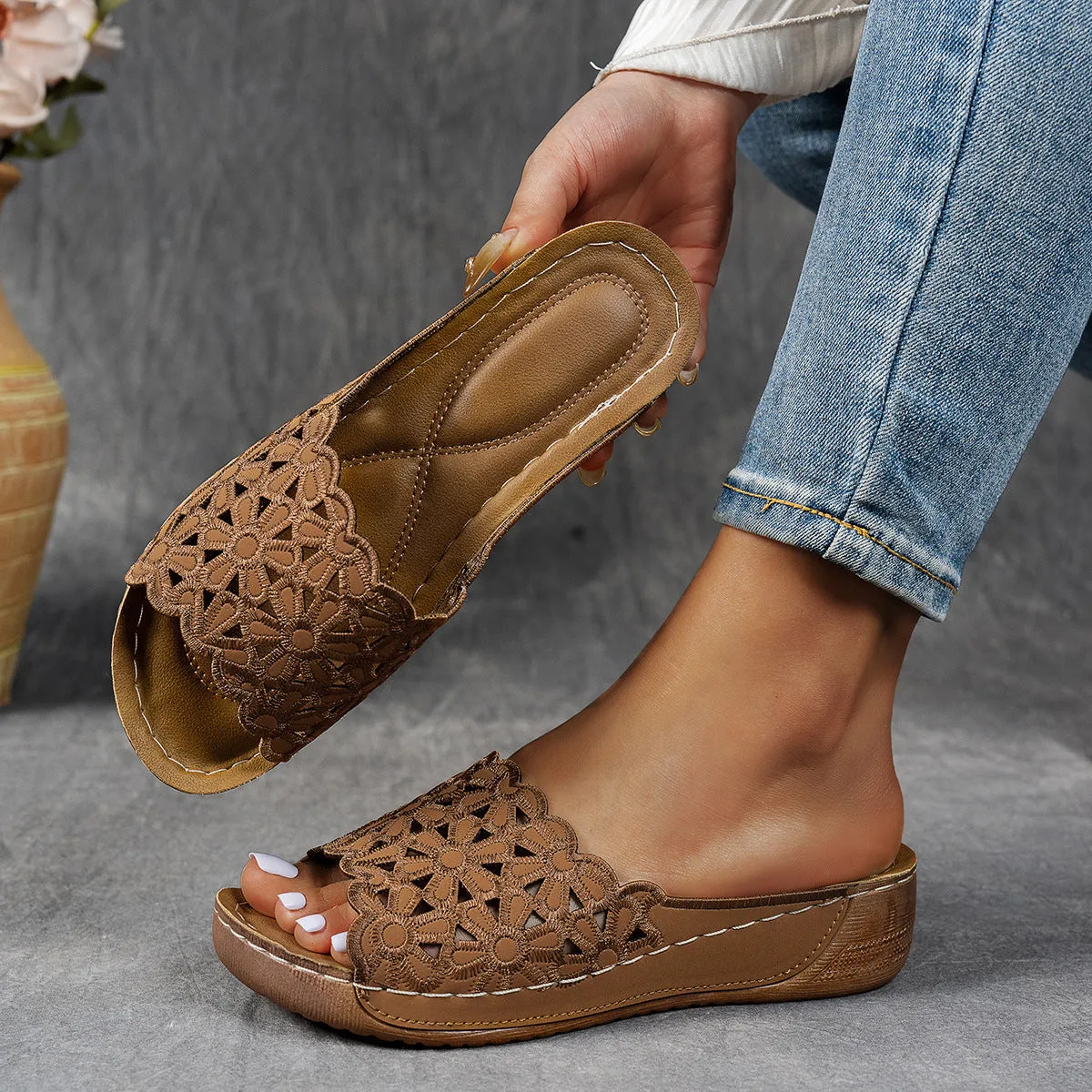 Women's black wedge beach slippers with flower cutout design and open fish mouth toe.