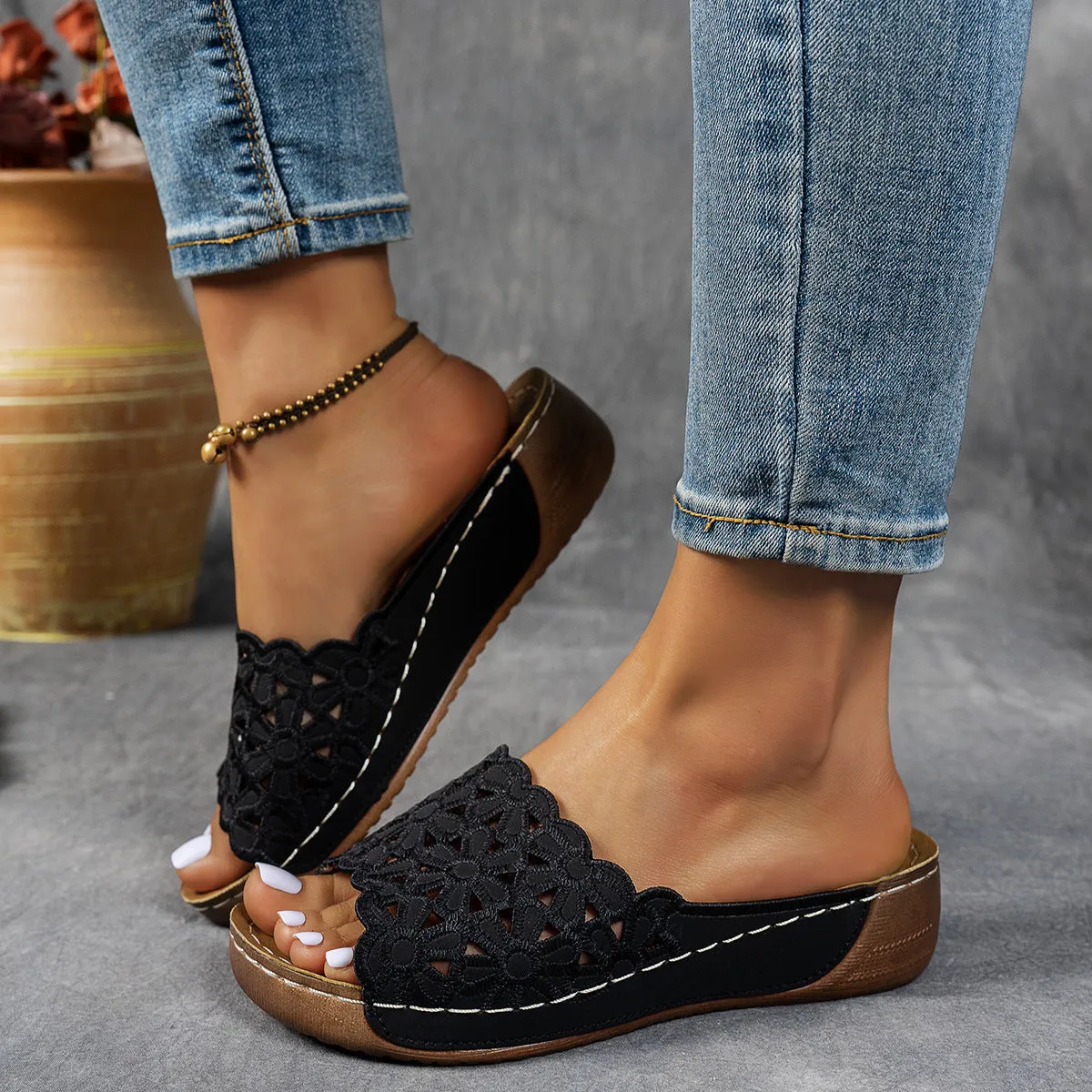 Women's black wedge beach slippers with flower cutout design and open fish mouth toe.