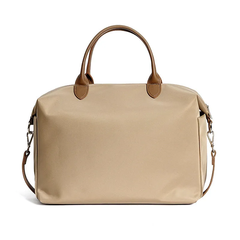 Black nylon waterproof shoulder bag with leather trim, showing large main compartment and shoulder strap.