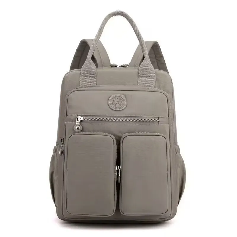Large soft nylon waterproof backpack in grey, open to show internal laptop, camera, and phone compartments.