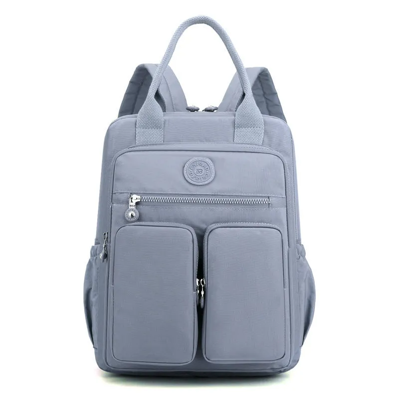 Large soft nylon waterproof backpack in grey, open to show internal laptop, camera, and phone compartments.