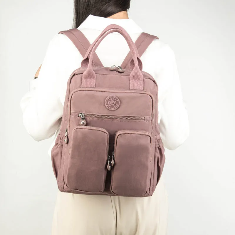 Large soft nylon waterproof backpack in grey, open to show internal laptop, camera, and phone compartments.