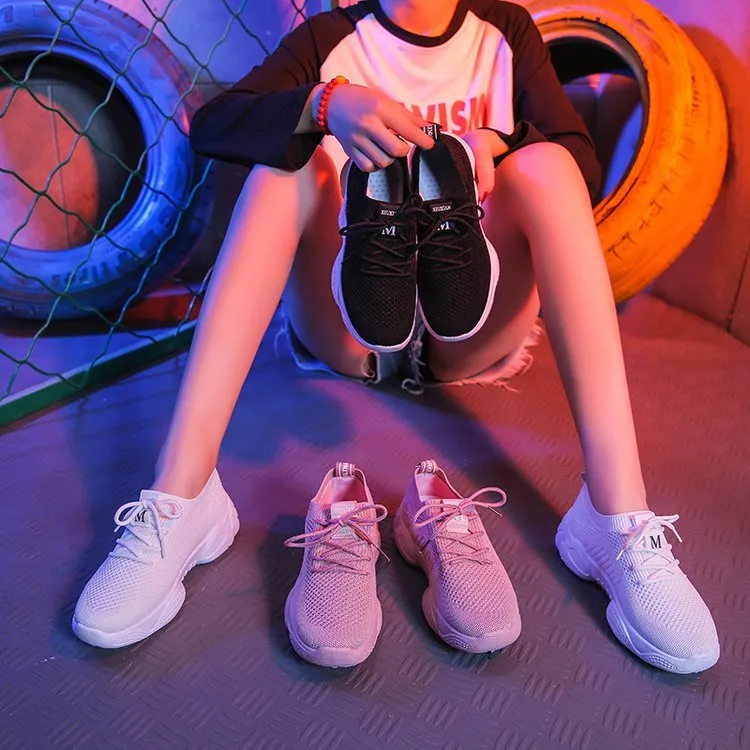 White thick-soled women's flyknit trainers with front strap and rubber sole.