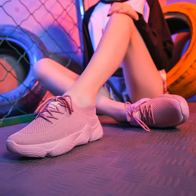 White thick-soled women's flyknit trainers with front strap and rubber sole.
