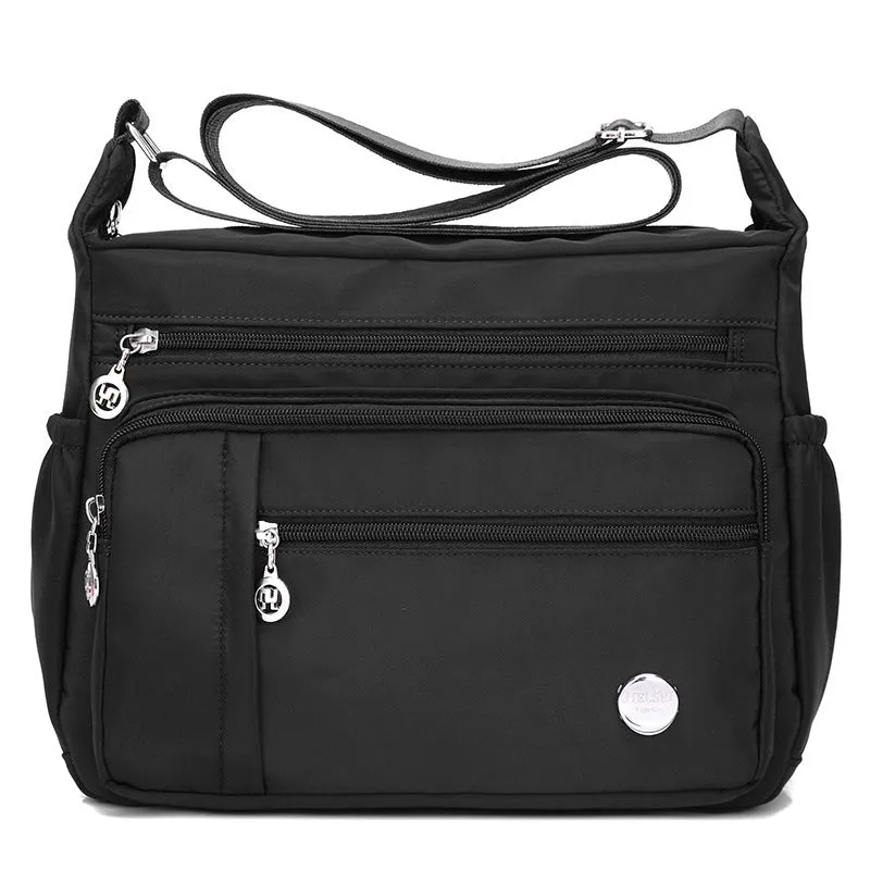 Lightweight nylon women's one shoulder crossbody bag in black with horizontal square shape and visible sewing thread detail
