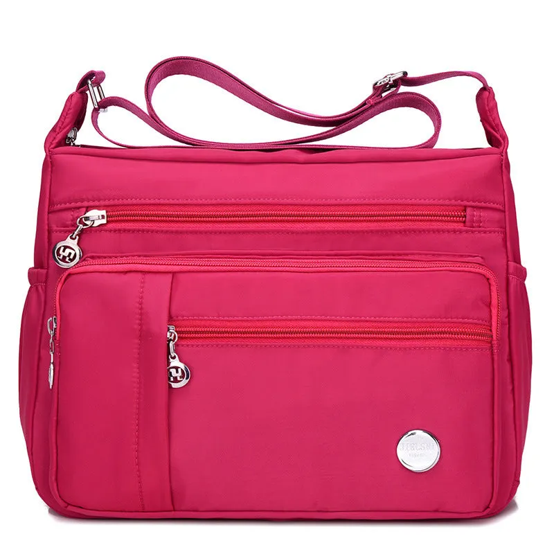 Lightweight nylon women's one shoulder crossbody bag in black with horizontal square shape and visible sewing thread detail