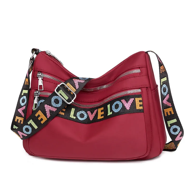 Soft oxford cloth crossbody shoulder bag with multiple pockets, letter stitching, available in black and red