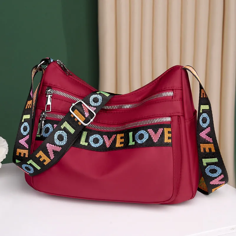 Soft oxford cloth crossbody shoulder bag with multiple pockets, letter stitching, available in black and red