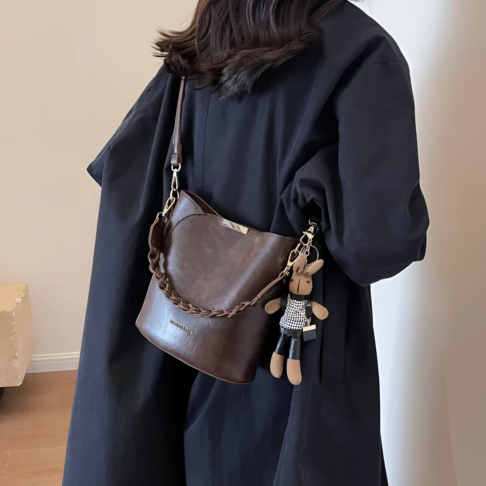 Women's retro PU messenger bag in brown with compact bucket shape, pendant, and double shoulder strap connector