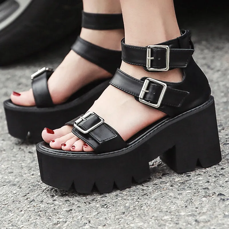 Black punk-style women's sandals with a thick chunky heel, round toe, buckle detail and back zipper.