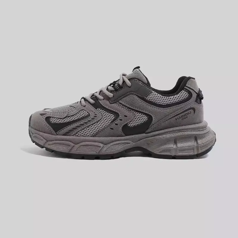 Grey chunky platform sneakers with leather stitching and lace-up design on a white background.
