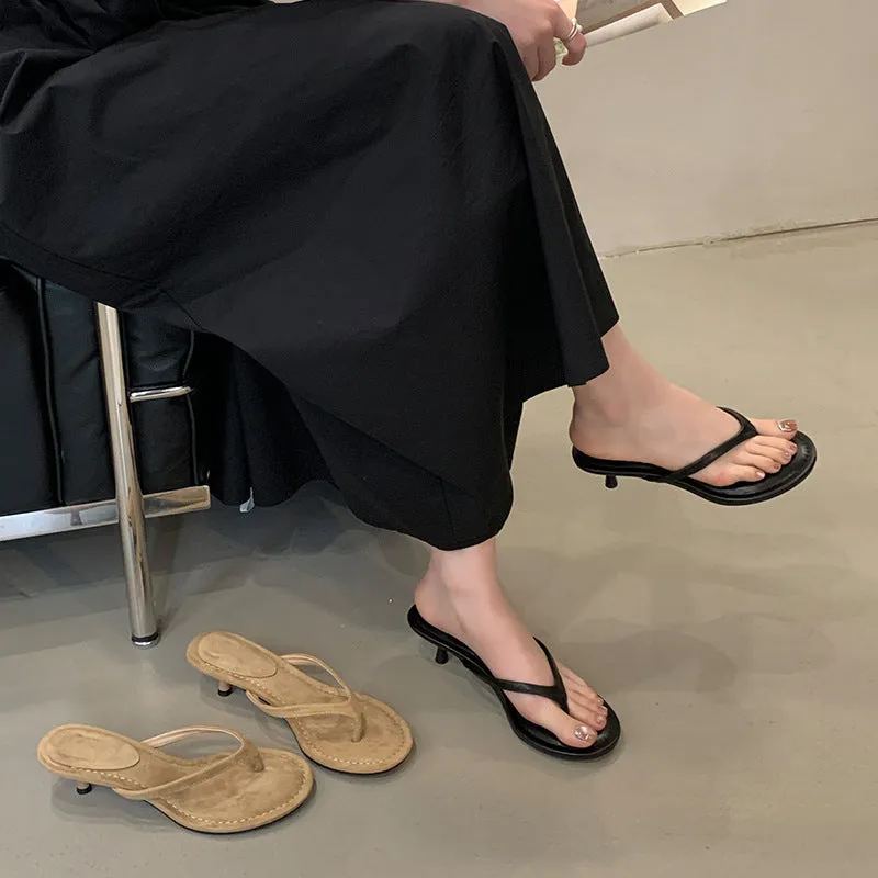 Women's black rubber stiletto flip-flops with round toe and flat head cap on a plain background.