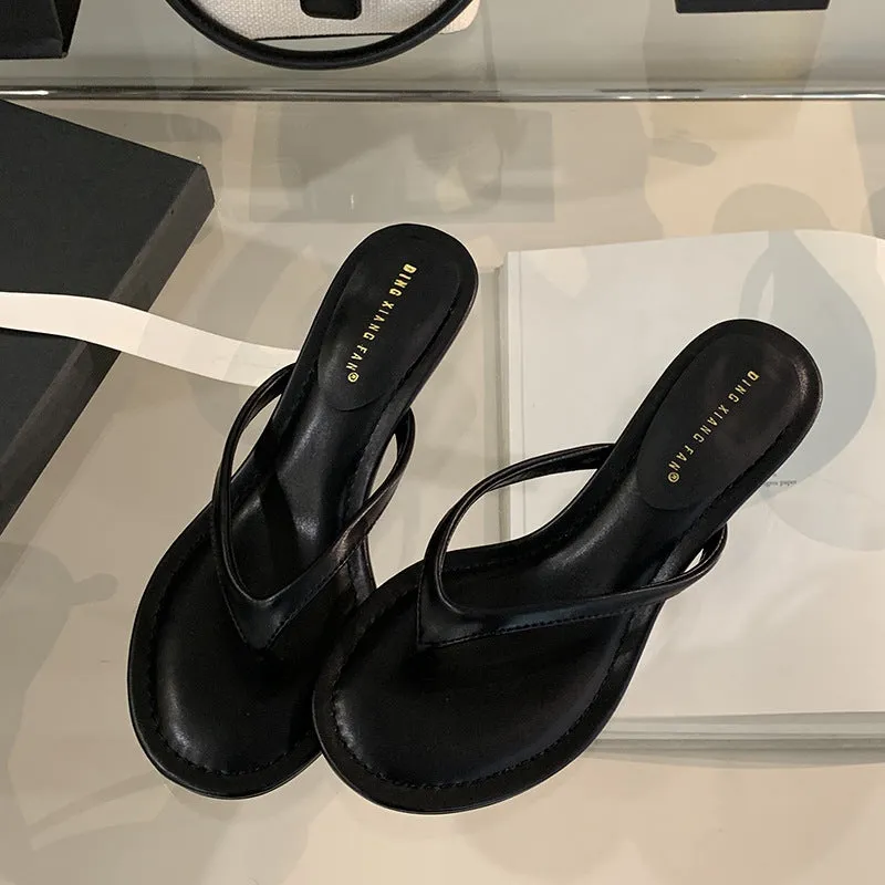 Women's black rubber stiletto flip-flops with round toe and flat head cap on a plain background.