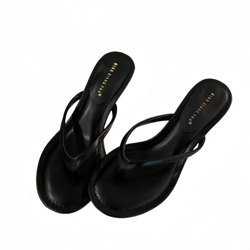 Women's black rubber stiletto flip-flops with round toe and flat head cap on a plain background.