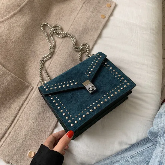 Small PU shoulder messenger bag for women with lock detail, chains, and rivet decoration on a soft flap.