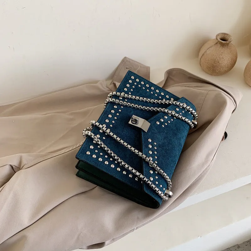 Small PU shoulder messenger bag for women with lock detail, chains, and rivet decoration on a soft flap.