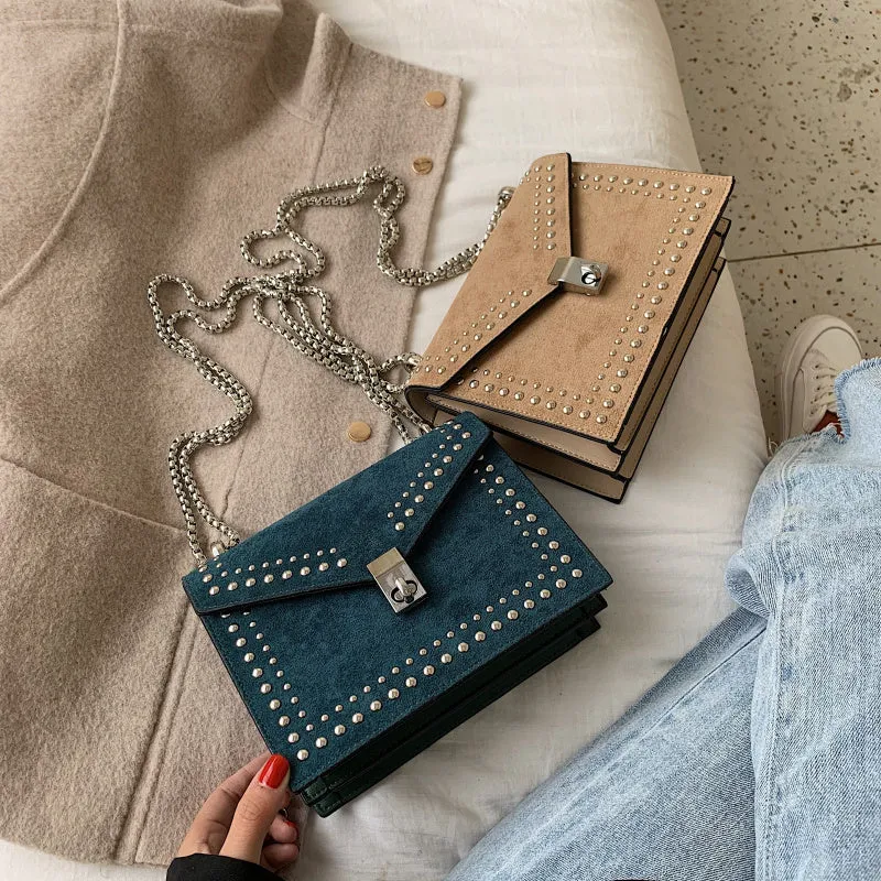 Small PU shoulder messenger bag for women with lock detail, chains, and rivet decoration on a soft flap.