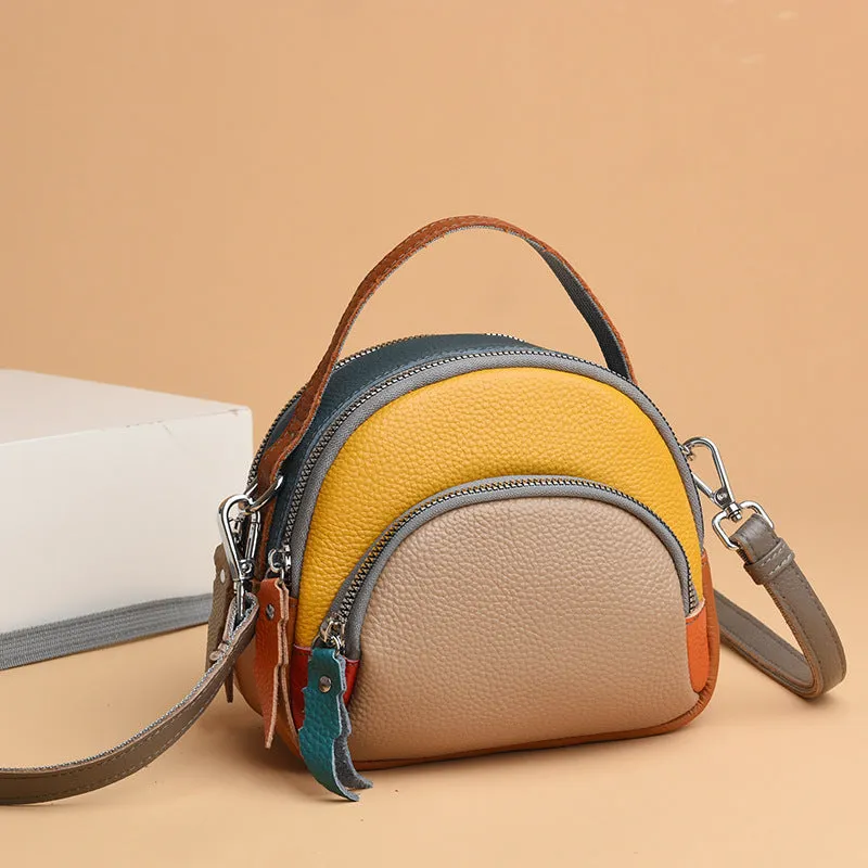 Round hand-held crossbody bag made from first layer cowhide leather with visible sewing line detail on exterior