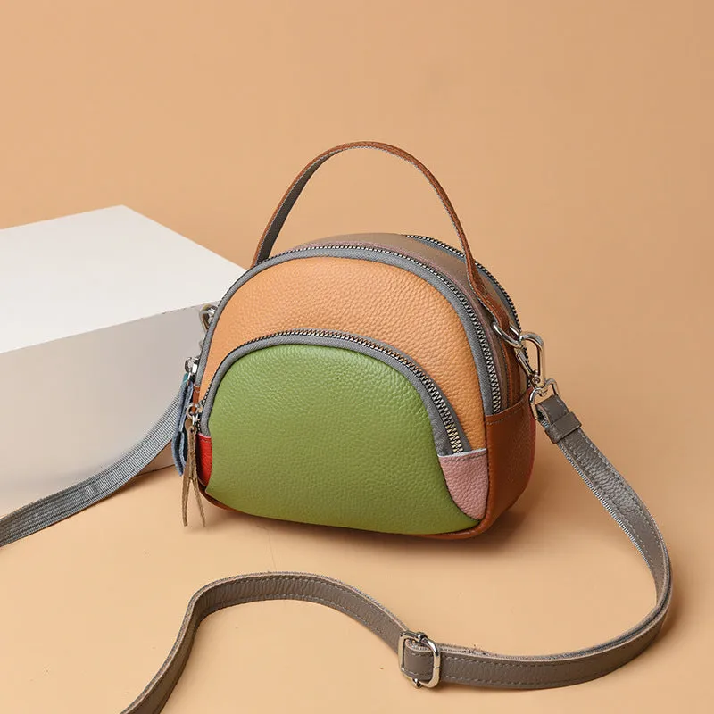 Round hand-held crossbody bag made from first layer cowhide leather with visible sewing line detail on exterior