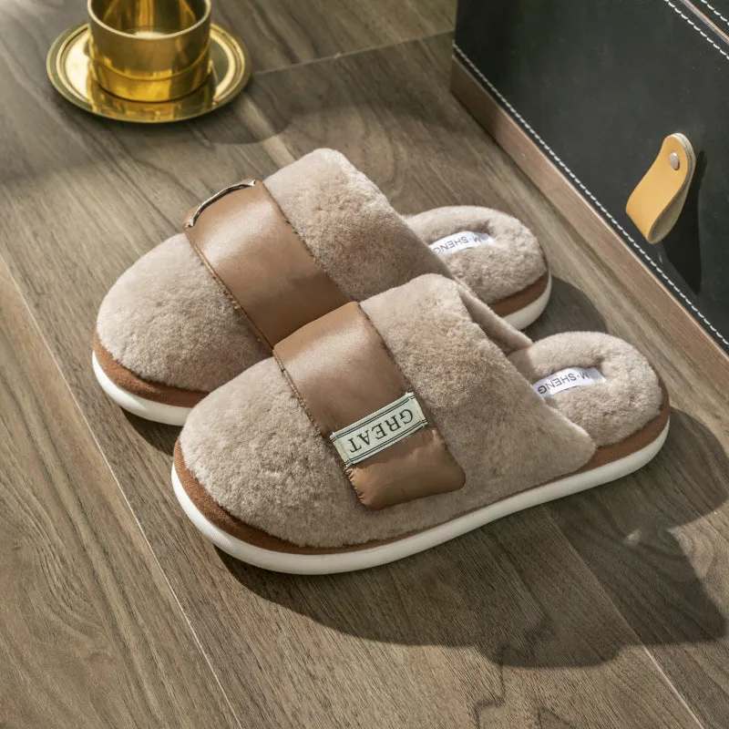Beige plush velcro slippers with a round toe and non-slip plastic sole on a wooden floor.