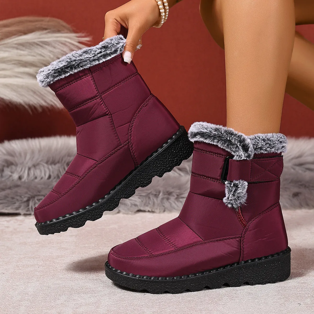 Women's snow boots in black with buckle fastening and round toe